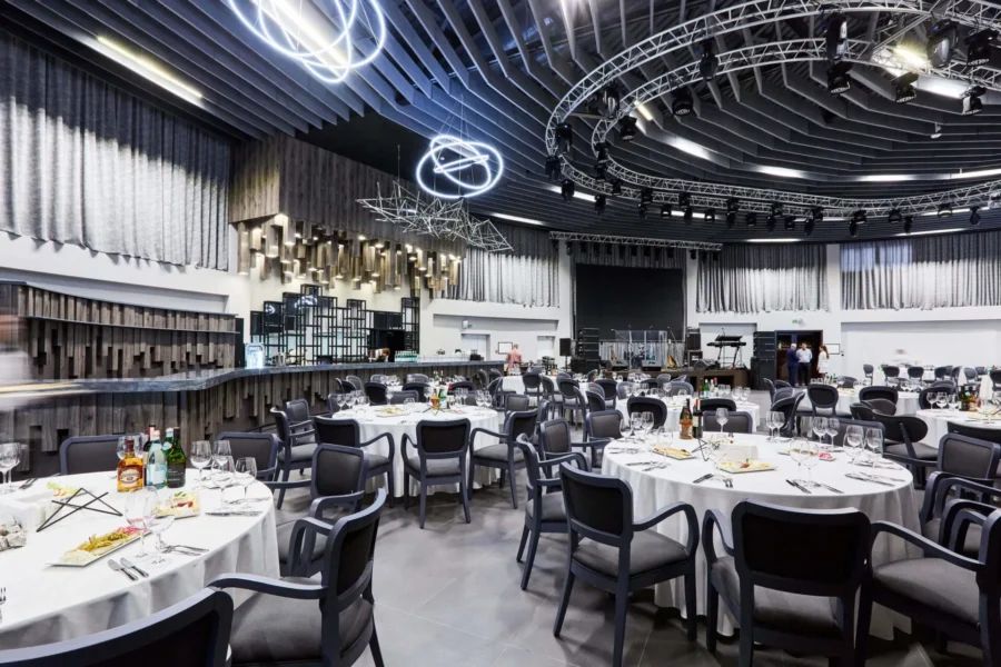 Роскошный интерьер банкетного зала Astoria с хрустальными люстрами и белыми скатертями на круглых столах