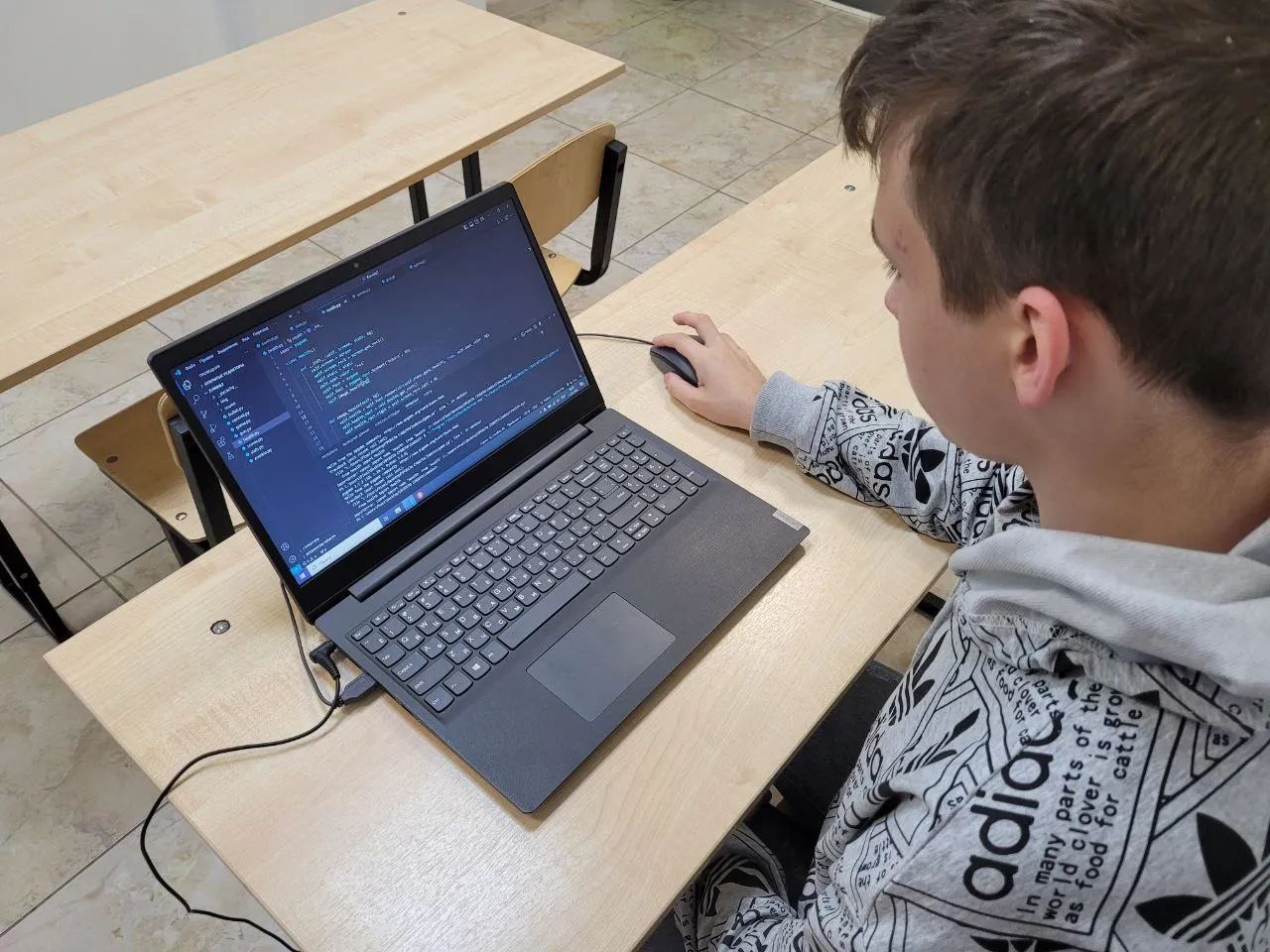Подростки изучают программирование на Python за компьютерами