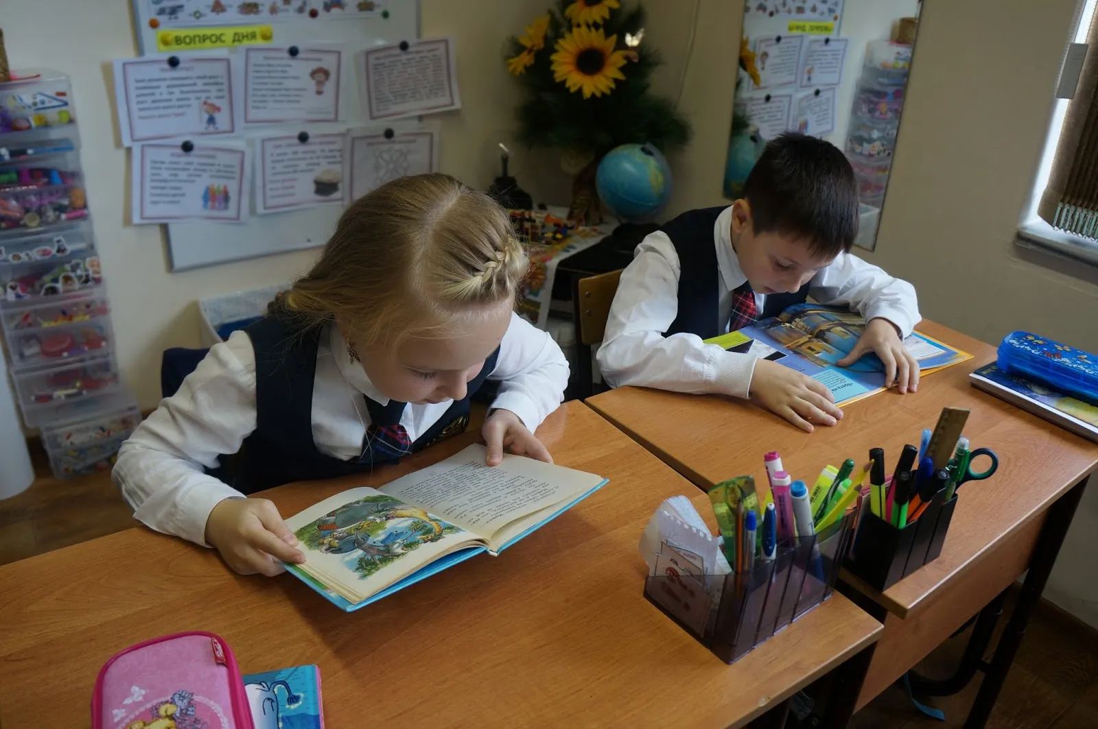 Школьники читают книгу за партой в семейной школе IQ School