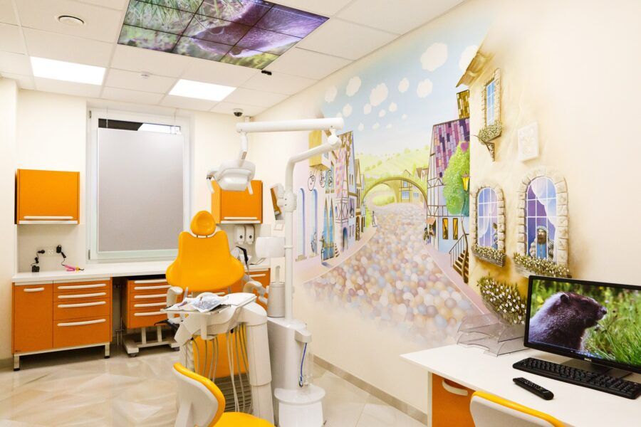Яркий интерьер клиники Стомазаврик с разноцветной мебелью и игровой зоной для детей