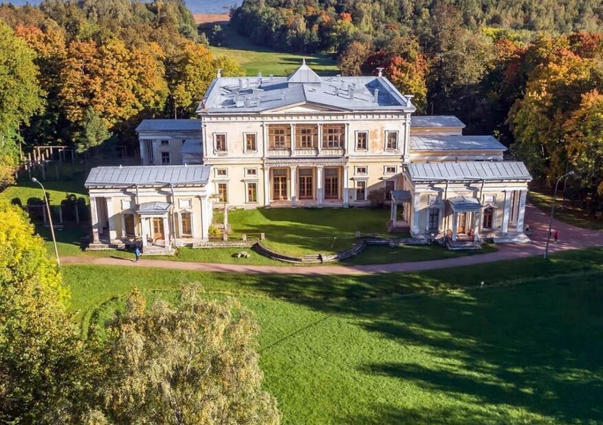 Белый дворец в неоклассическом стиле среди парка