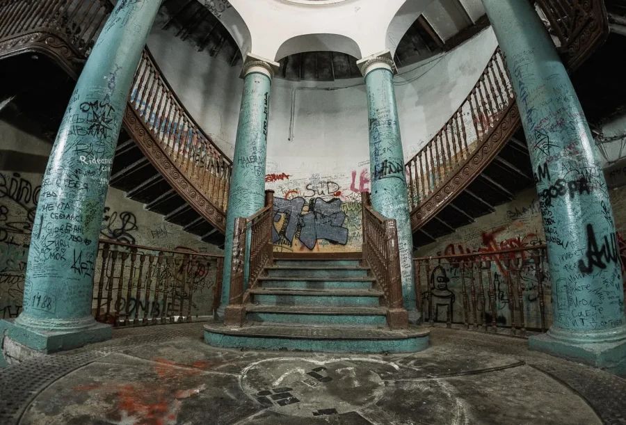 Круглый зал Ротонды на Гороховой со старинной винтовой лестницей и колоннами, стены исписаны граффити