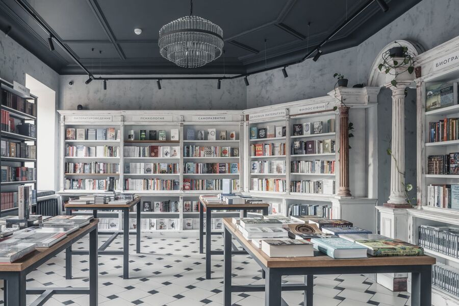 Современный интерьер книжного магазина Во весь голос с минималистичным дизайном, продуманной подсветкой и элегантной выкладкой книг