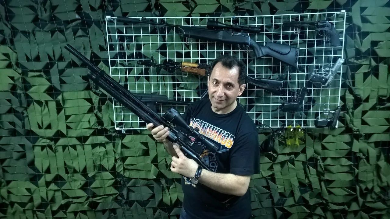 Инструктор тира «Меткий выстрел» помогает посетителям освоить стрельбу
