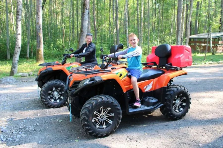 Квадроцикл на базе отдыха Рыбачий Берег на фоне коттеджей и живописного озера