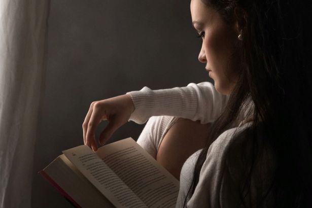 Девушка внимательно читает книгку