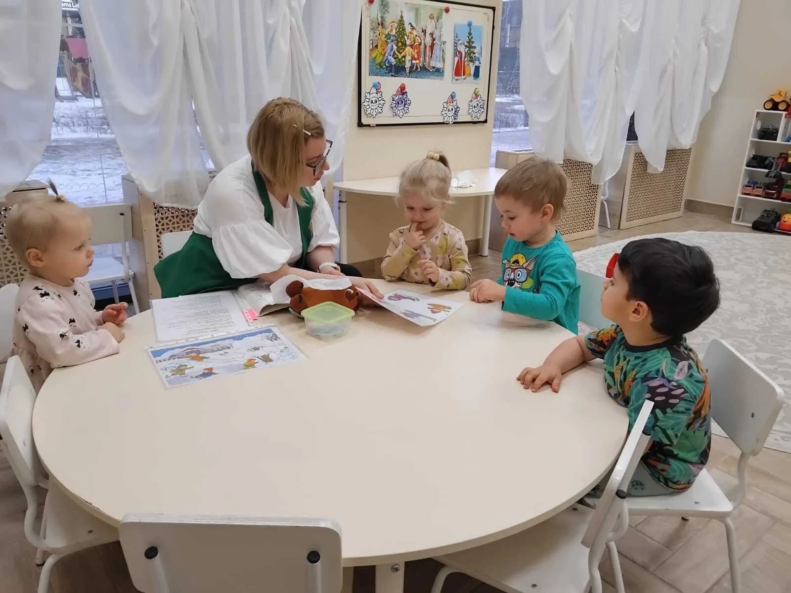 Педагог читает книгу группе детей в логопедическом центре в Санкт-Петербурге