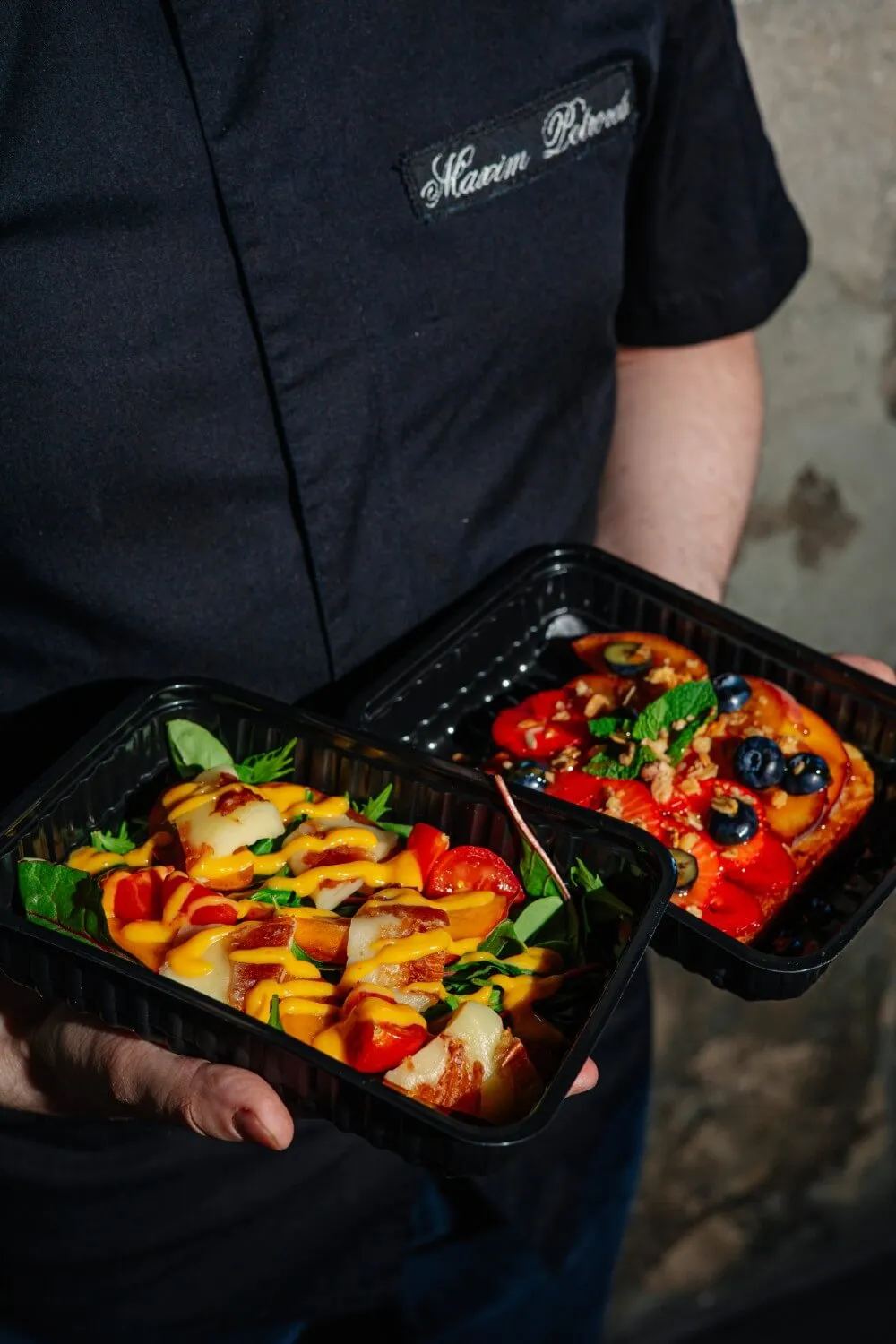 Два контейнера BlackBFood в руках курьера