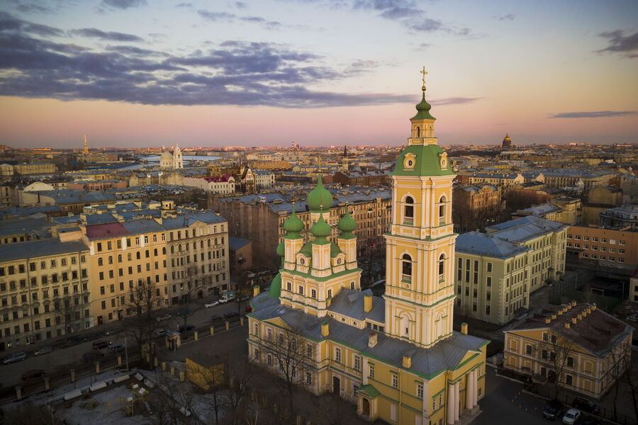 Благовещенская церковь на Васильевском острове с жёлто-зелёным фасадом, окружённая садом