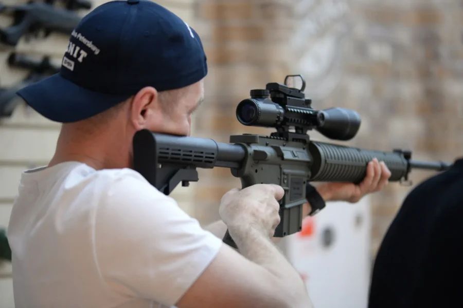 Посетитель целится из традиционного лука в КЛАД, на заднем плане видны разнообразные мишени и другие стрелки