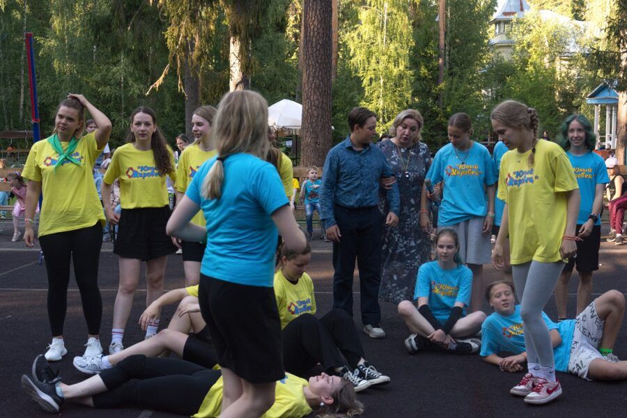 Территория лагеря Юный кировец с футбольным полем, спортивными площадками и хвойным лесом