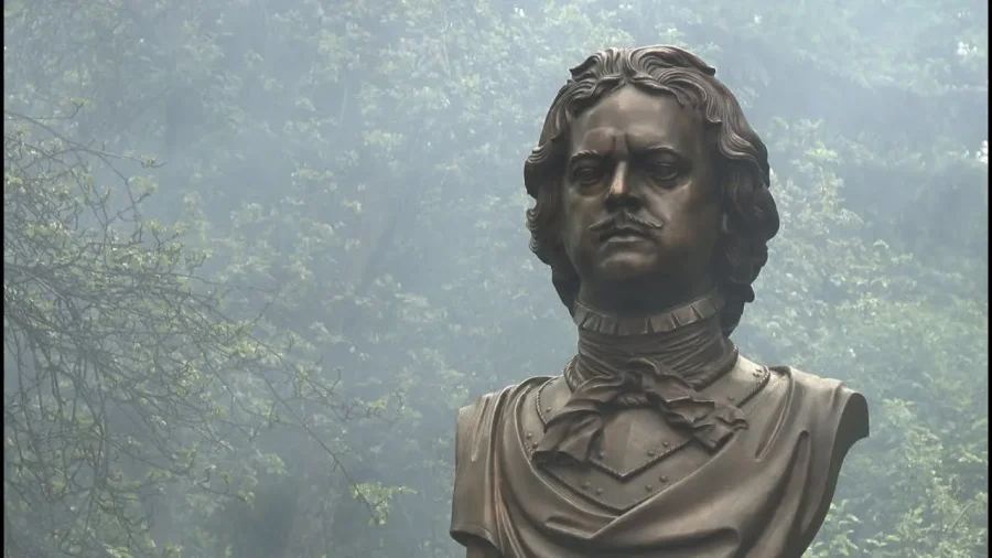Бронзовый памятник Петру Великому на постаменте в университетском парке