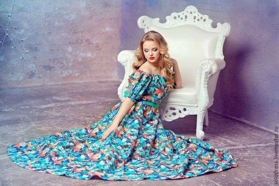 Интерьер ателье SolOdress с примерами женских дизайнерских платьев и швейным оборудованием