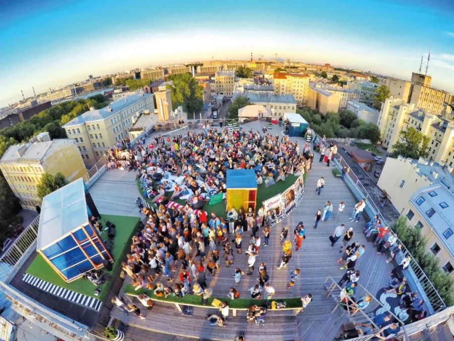 Панорамная крыша лофт-проекта ЭТАЖИ с видом на городские крыши и яркими зонами отдыха для гостей