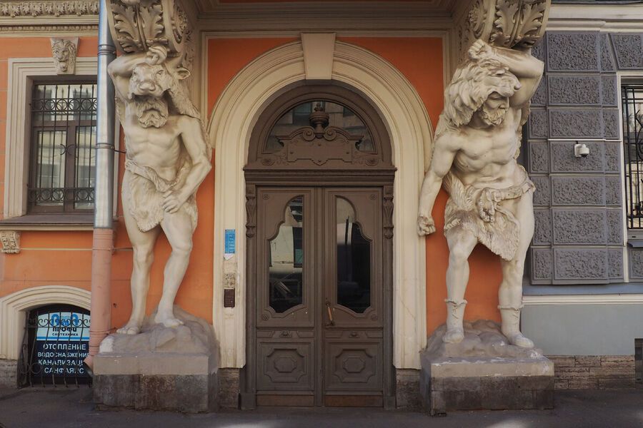 Гротескные атланты-варвары в звериных шкурах на фасаде дома в Саперном переулке