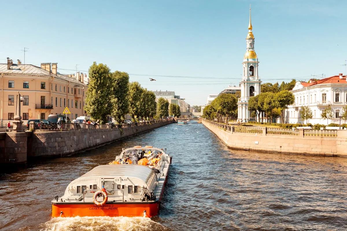 Теплоход на канале Петербурга днём на фоне исторической застройки