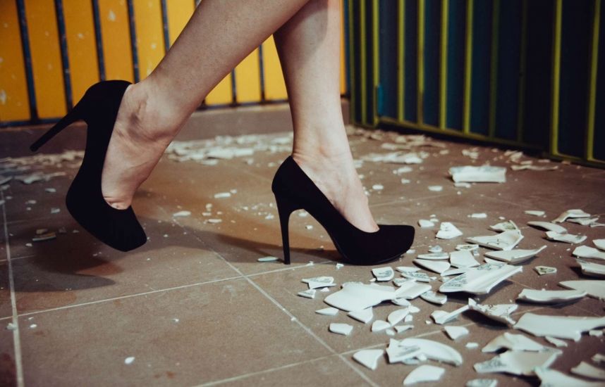 Специальное помещение с защитными стенами где посетитель в экипировке бьет посуду в аттракционе Бей посуду