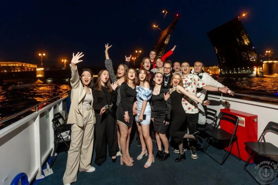 Белый двухпалубный теплоход компании Нева-Тревел проходит под разводным мостом во время белых ночей