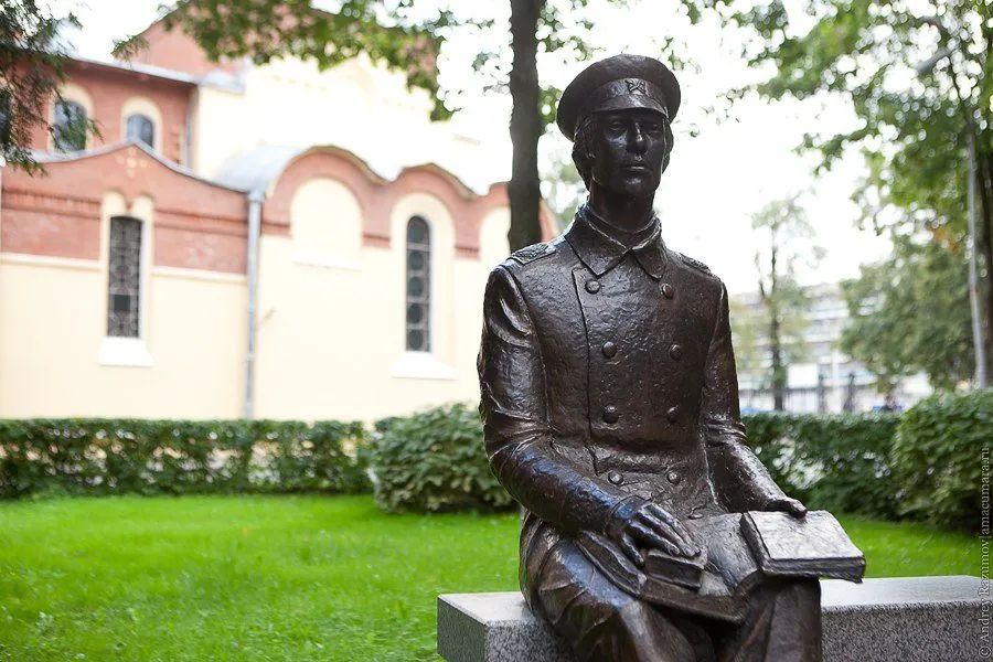 Бронзовый памятник студенту-политехнику в форме начала XX века, сидящему на скамейке с книгами