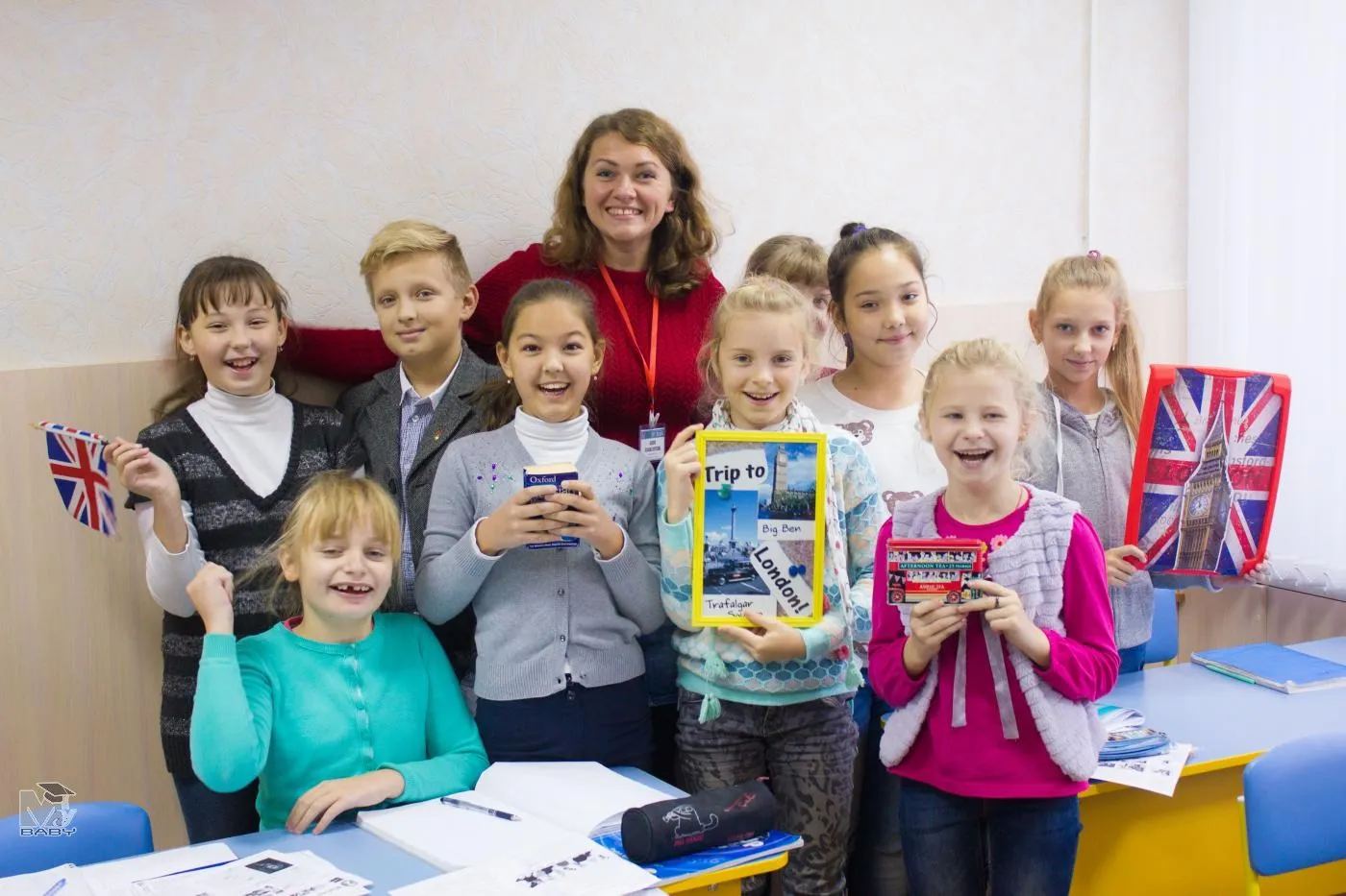 Преподаватель и дети с британскими флажками в Benedict School