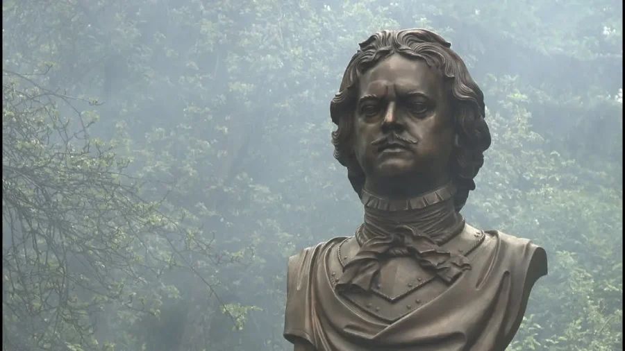 Бронзовый памятник Петру Великому на постаменте в университетском парке