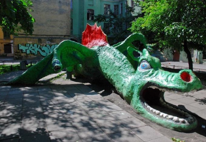 Цементная скульптура зеленого дракона во дворе между 7-й и 8-й линиями