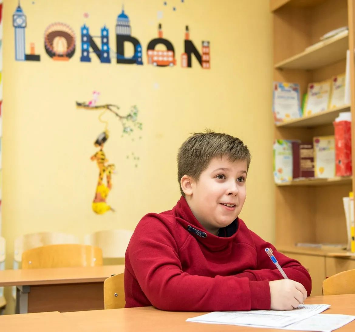 Ребёнок пишет под буквами LONDON в центре Orange Language Centre