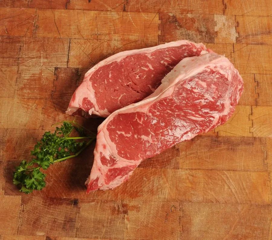 Стейки мраморной говядины Black Angus на деревянной доске в Экоферме Семейная