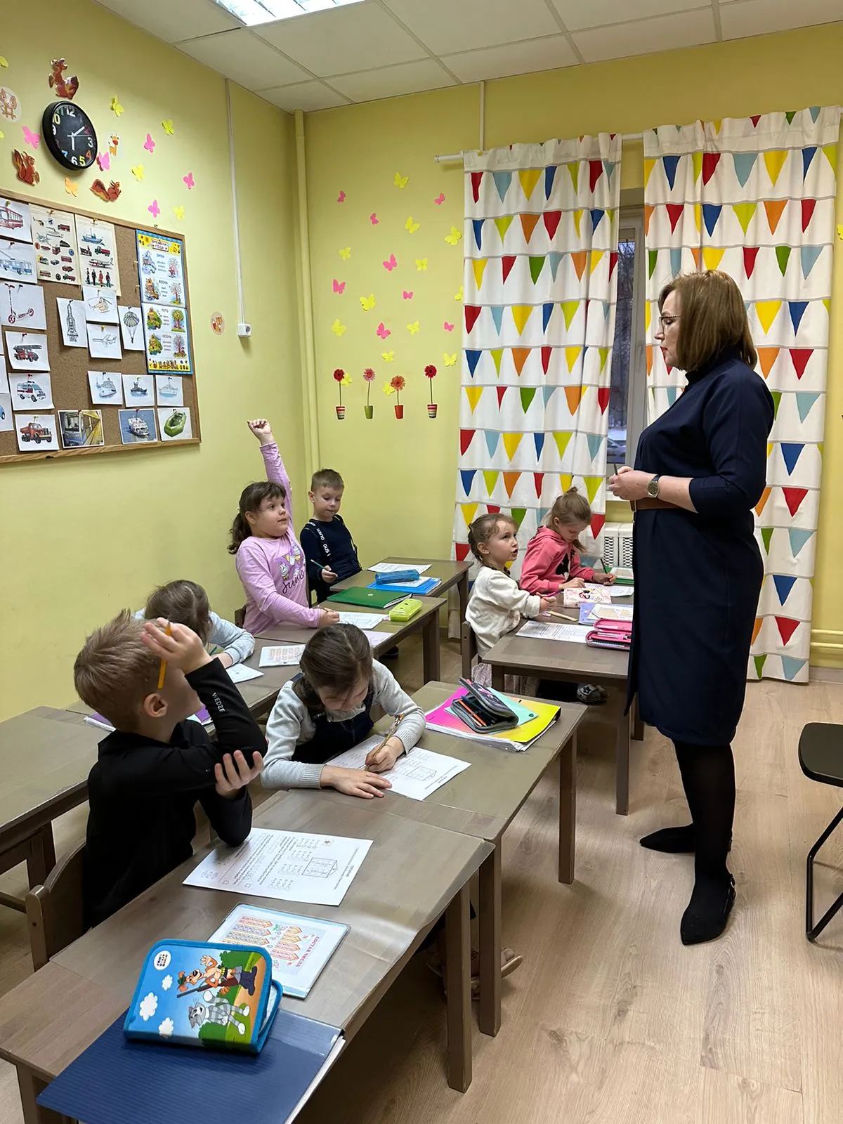 Дети за партами и педагог в классе центра развития WUNDER-KINDER