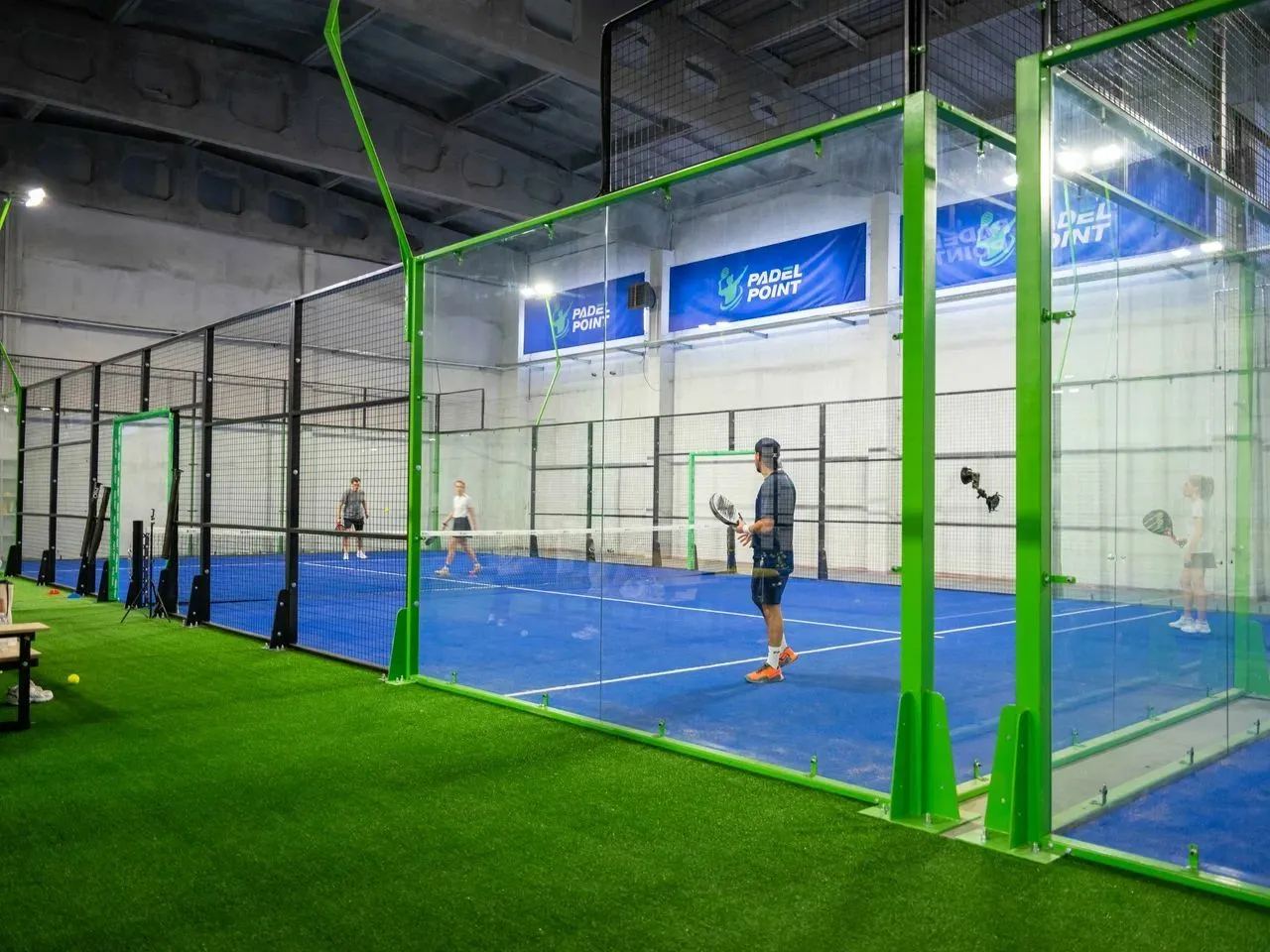 Игра на корте с логотипом Padel Point на стене