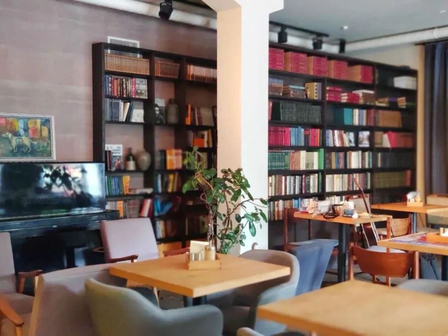 Атмосферный интерьер арт-клуба Книги и Кофе с книжными полками и уютным пространством для чтения
