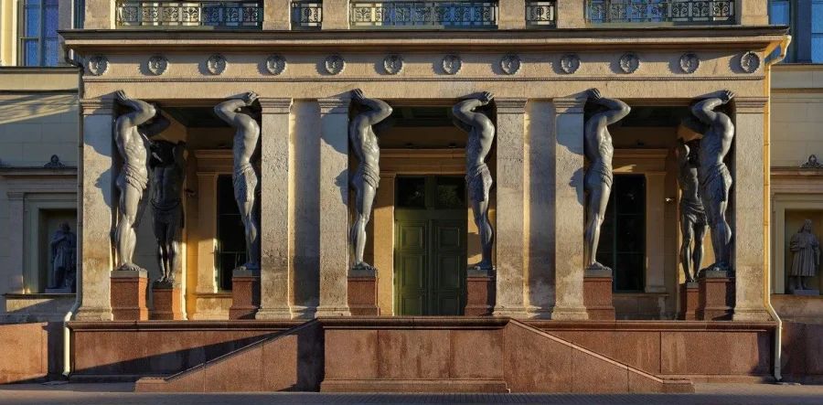 Величественные атланты у входа в Эрмитаж, поддерживающие балкон здания