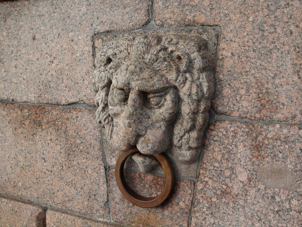 Каменные львы на Стрелке Васильевского острова с видом на Неву и Петропавловскую крепость