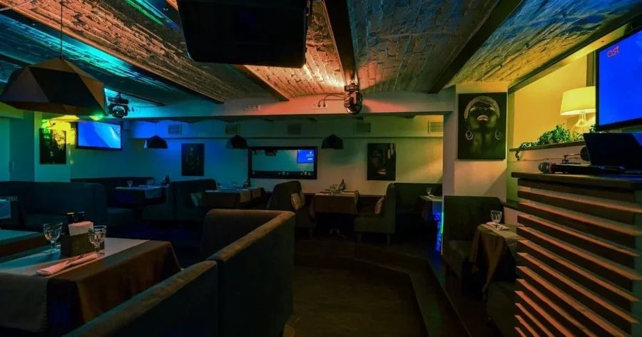 Уютный зал караоке-бара Vunison с мягкими диванами и профессиональной сценой