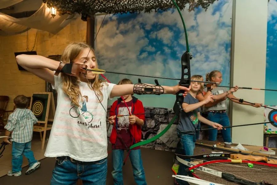Инструктор показывает технику стрельбы из лука в тематическом клубе Шервуд в Санкт-Петербурге